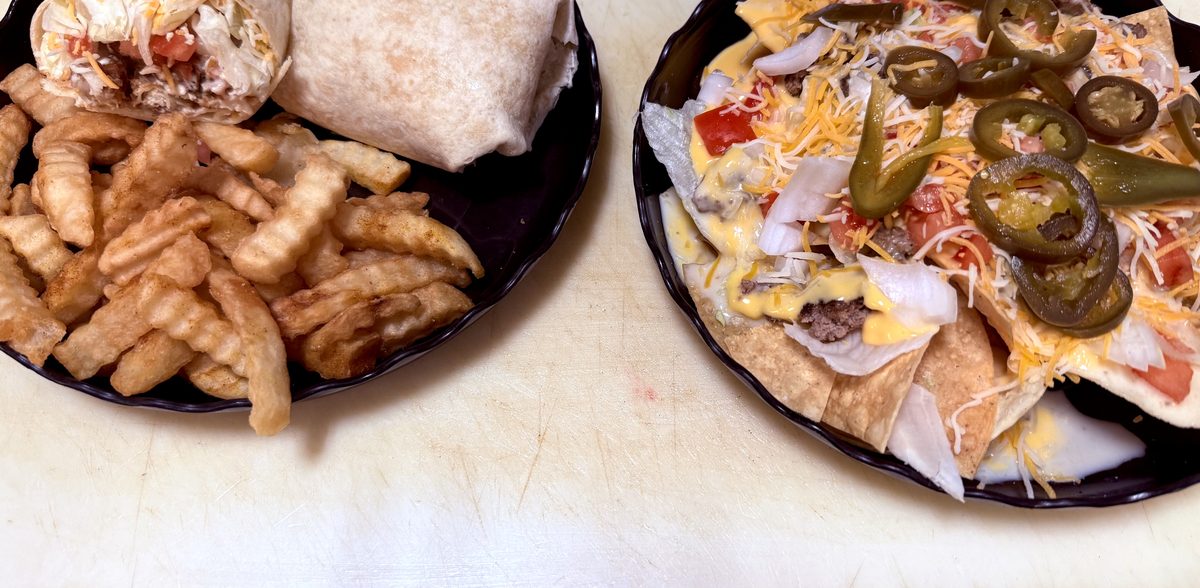 Burger wrap with crinkle fries next to loaded nachos with jalapeños